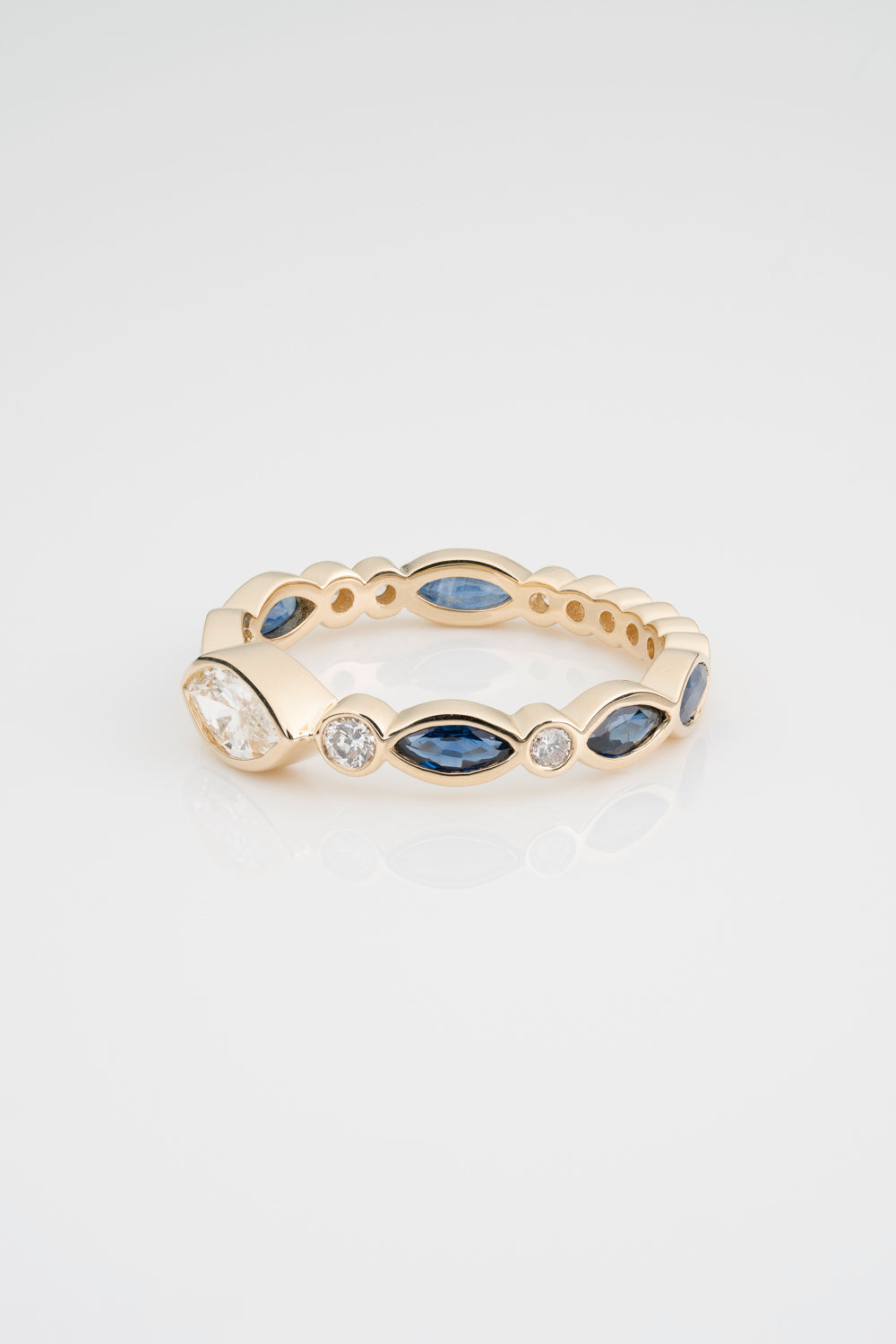 Custom Diamond and Sapphire Eternity Band sprinkled with White Diamond Marquise, Blue Sapphires, and Round White Diamonds. Stones are fully bezel set in 14k Yellow Gold