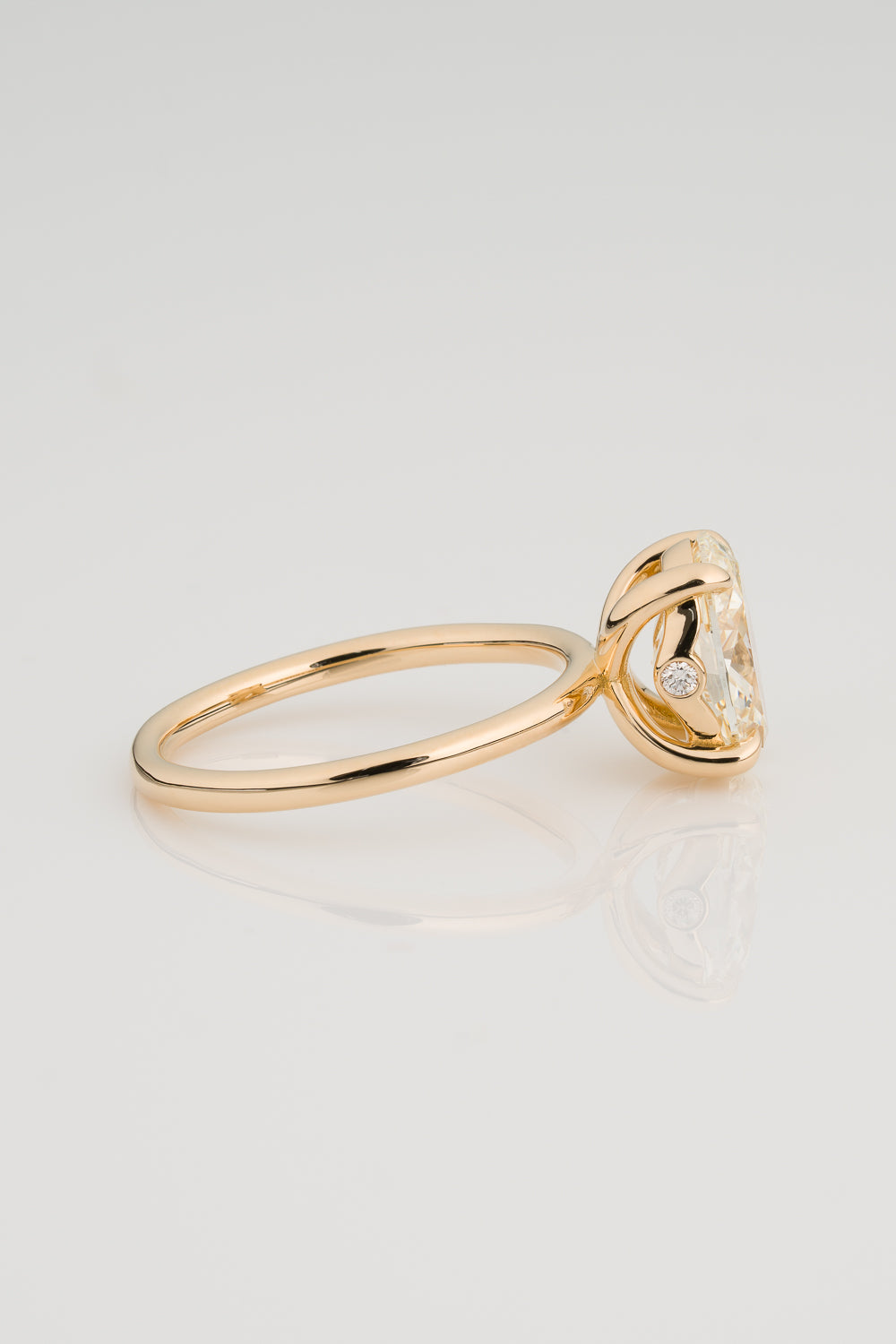 Oval Diamond Solitaire with a Sculptural Setting and unexpected Diamond Detail on the setting.