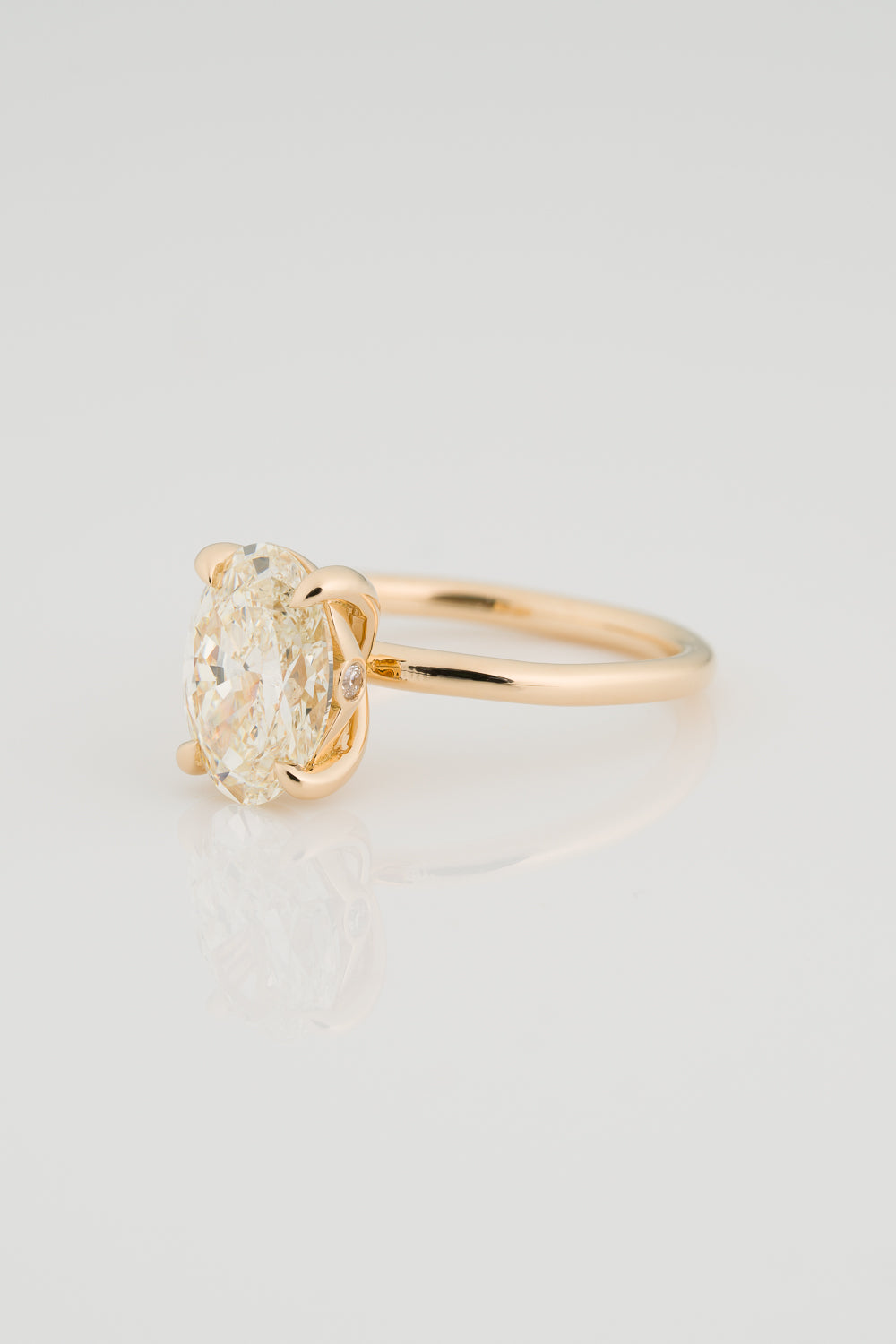 Oval Diamond Solitaire with a Sculptural Setting and unexpected Diamond Detail on the setting.
