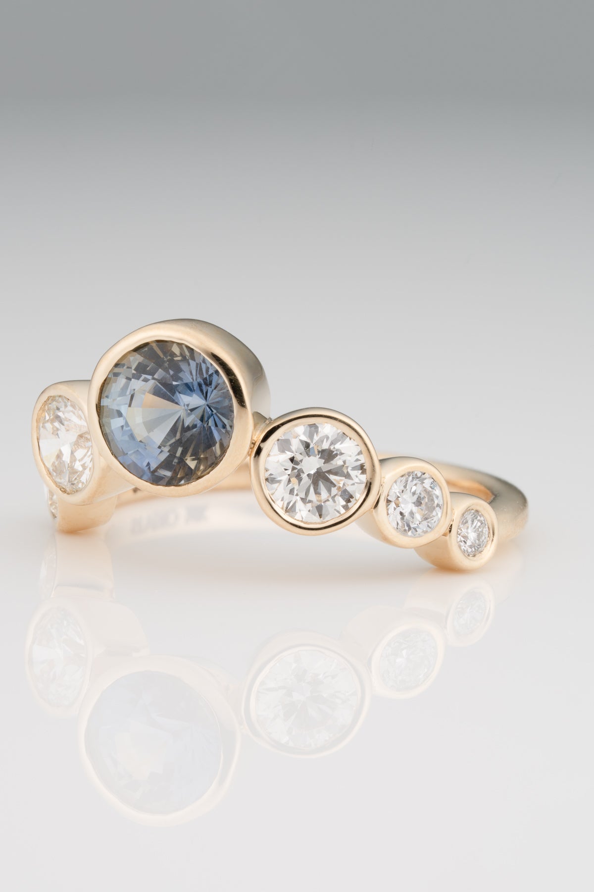 A one-of-a-kind bi-color brilliant-cut sapphire flanked by white diamonds