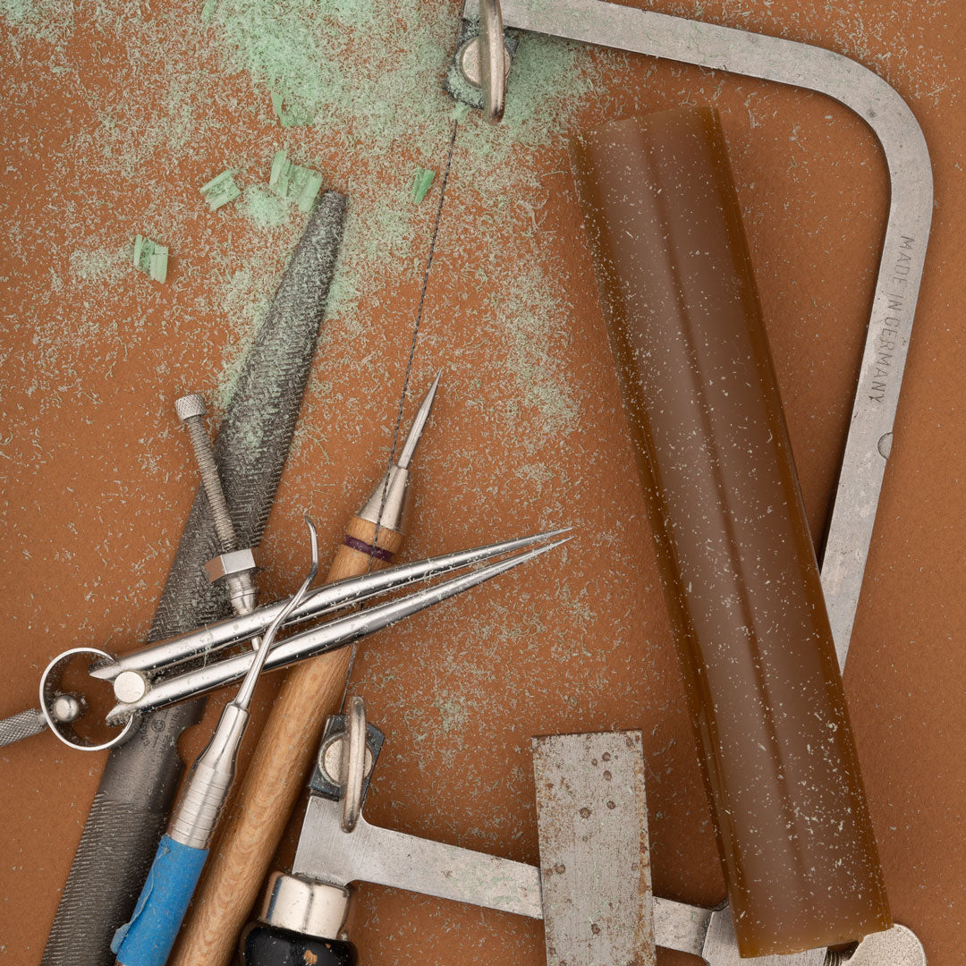A collection of shaping tools covered in green wax dust on a table