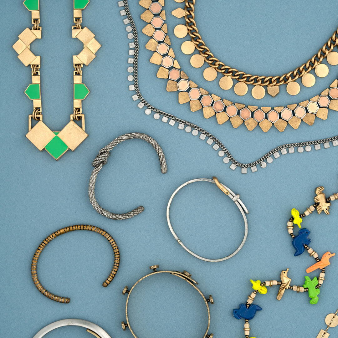 A collection of costume jewelry necklaces and bracelets organized on a blue background
