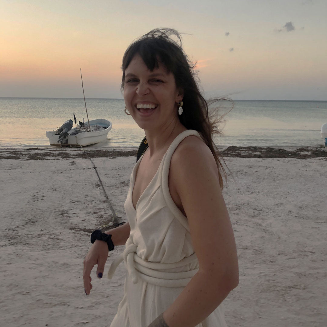 Erica smiling and laughing on a beach at dusk