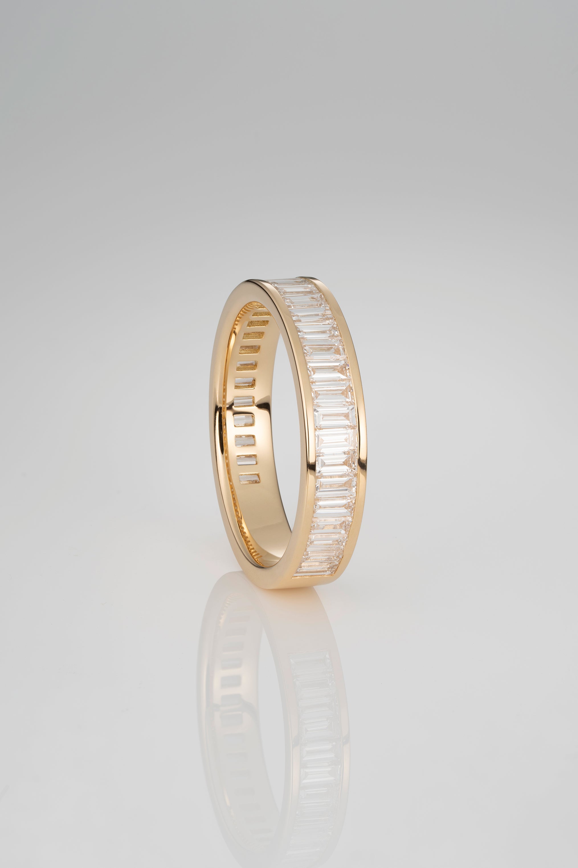 A Gold 3/4 Eternity Band with Channel Set White Diamonds in a North South orientation with a gold backing on a white background. 