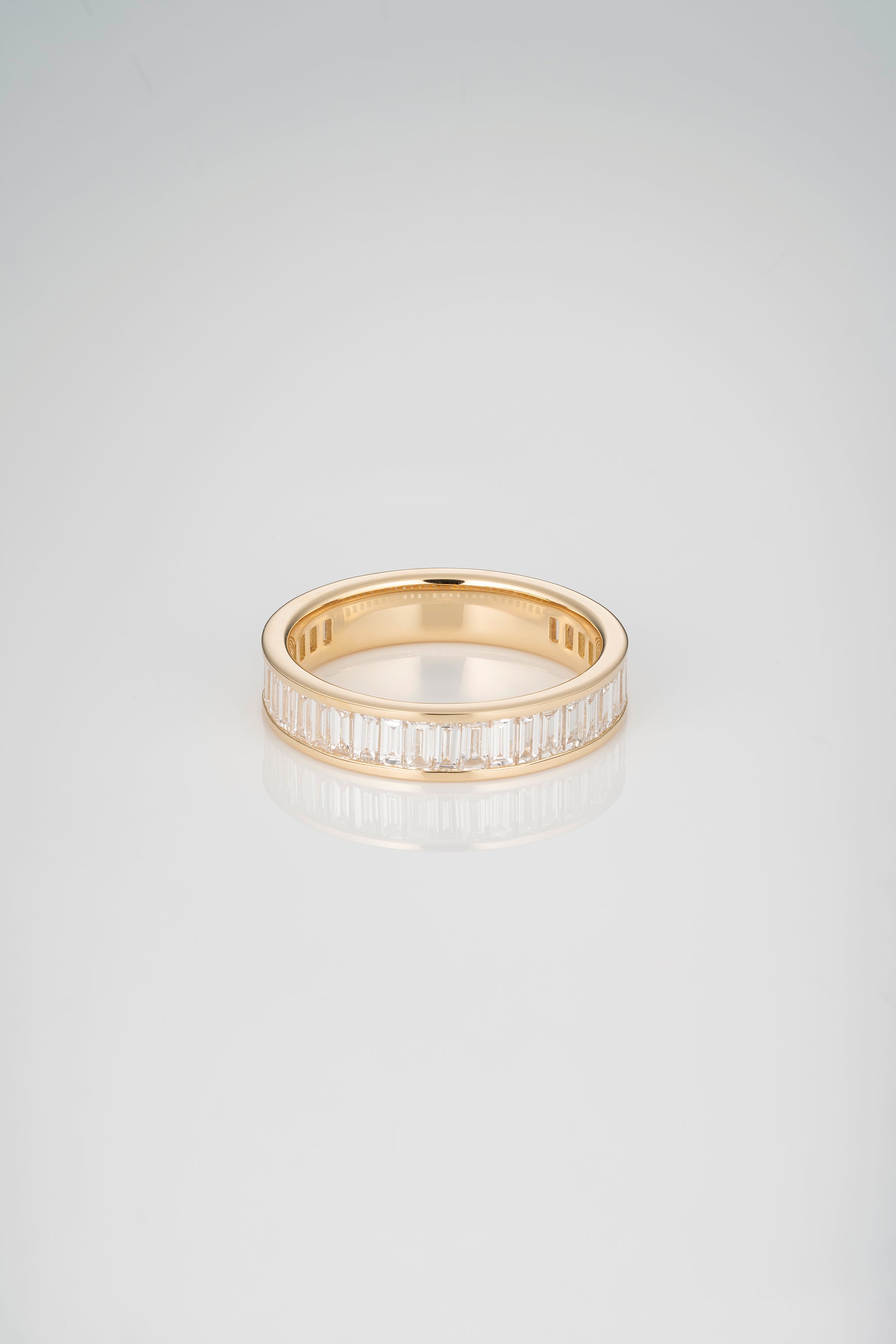A Gold 3/4 Eternity Band with Channel Set White Diamonds in a North South orientation with a gold backing on a white background. 