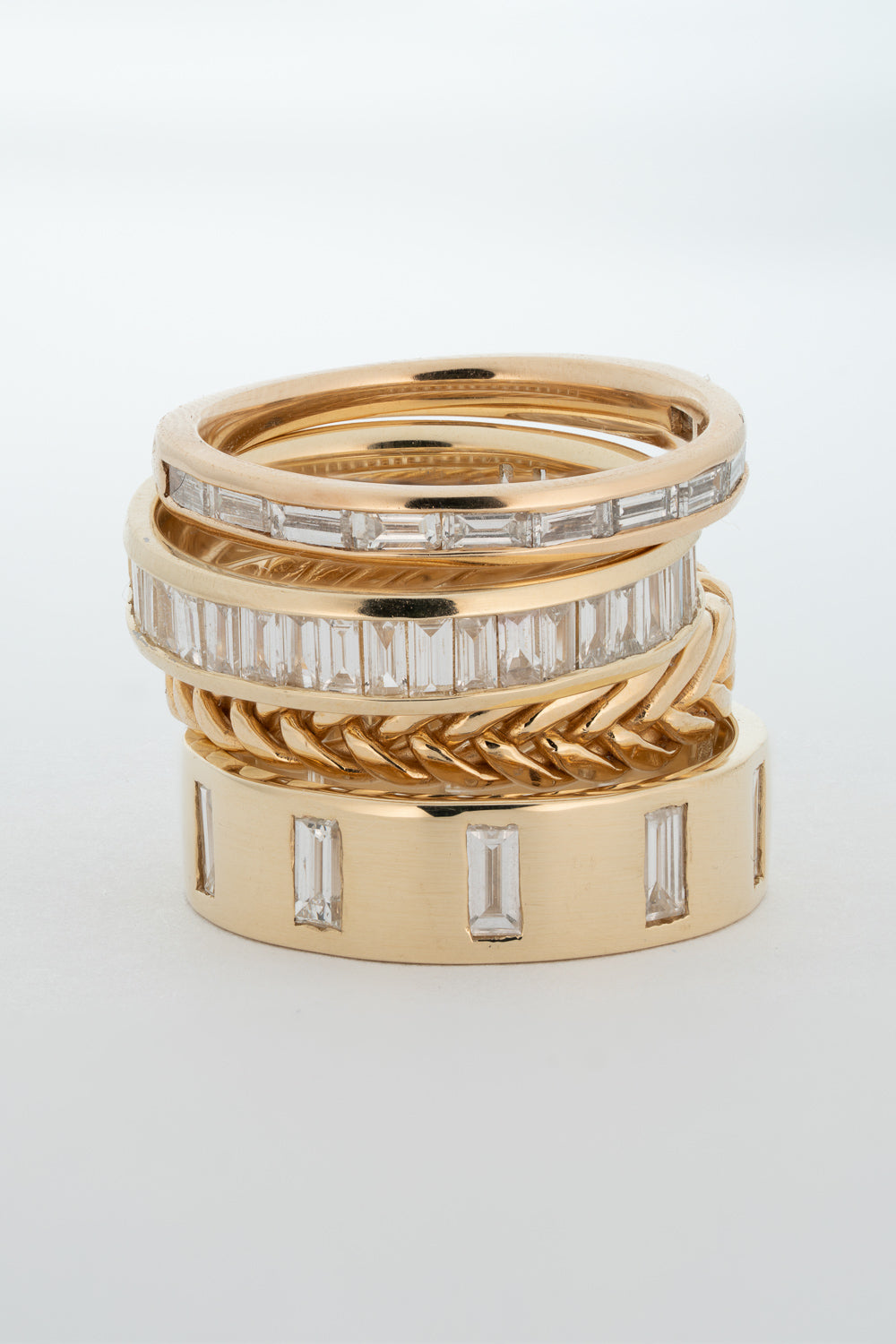 A stack of 14k gold rings using different settings